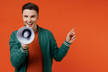 Excited fun young brunet man 20s wears red t-shirt green jacket hold scream in megaphone announces...