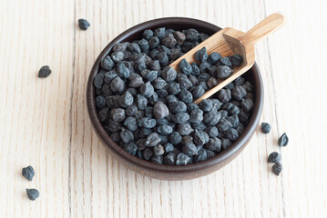 Black chickpeas in a wooden plate on a wooden backround