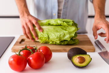 Young mixed race man preparing a salad for lunch