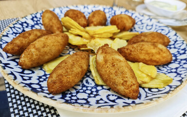 Close-up shot of homemade chicken croquettes and potato fries on the plate
