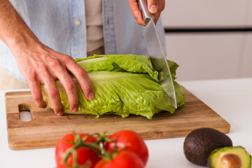 Young mixed race man preparing a salad for lunch