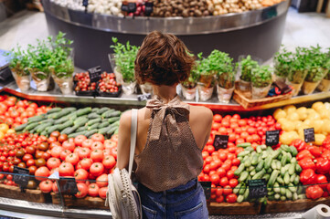 Back view young vegetarian happy woman wear casual clothes backpack shopping at supermaket...