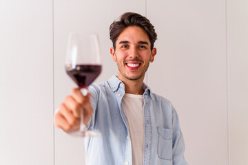 Young mixed race man drinking wine in a kitchen