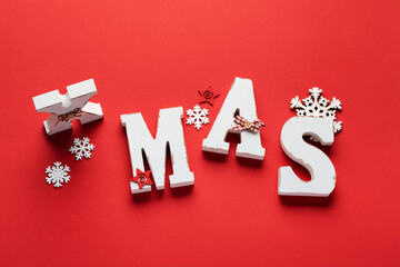 Old white volume letters Xmas and red cord, snowflakes on red background. Christmas banner. Top view. Flat lay. Mock up.