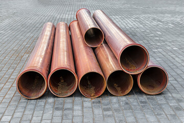 Orange sewer pipes lie on a construction site. Preparation for earthworks for the installation of an underground pipeline.