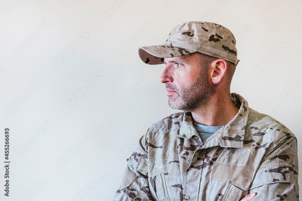 Wall mural Caucasian man in camouflaged army uniform crossing arms