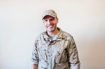 Caucasian man in camouflaged army uniform crossing arms
