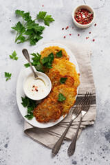 Draniki - potatof ritters, vegetarian potato pancakes, served with fresh herbs and garlic yogurt sauce, top view