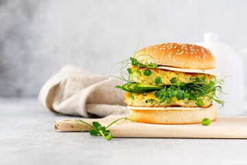 Healthy Vegetarian burger with egg and pea shoots and seeds microgreen, fresh salad, cucumber slice...