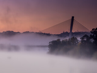Pont  surplombant le fleuve Mondego sous le brouillard au lever du soleil (Coïmbra, Portugal)