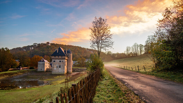Photographie du donjon du carondelet (Crupet, assesse, Wallonie, Belgique) prise au lever du jour (lever du soleil). Un léger brouillard est visible sur la route longeant le château). 