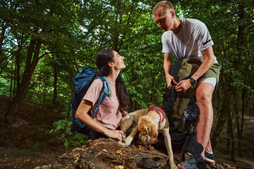 Joyful caring couple with pet in wood