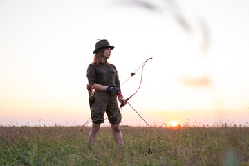 woman with bow outdoors in the field