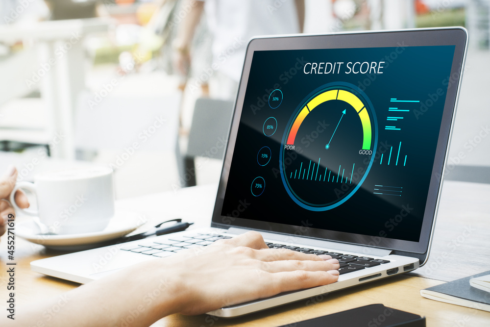 Poster close up of hands at wooden desktop with laptop computer, coffee cup and abstract credit score scale