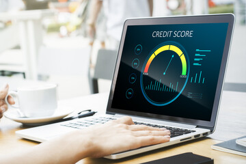 Close up of hands at wooden desktop with laptop computer, coffee cup and abstract credit score scale on screen. Finance and consumer concept.