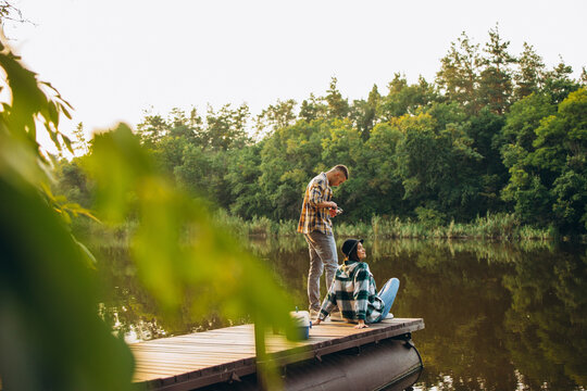 Portrait of young couple fishing on warm summer day in countryside at sunset