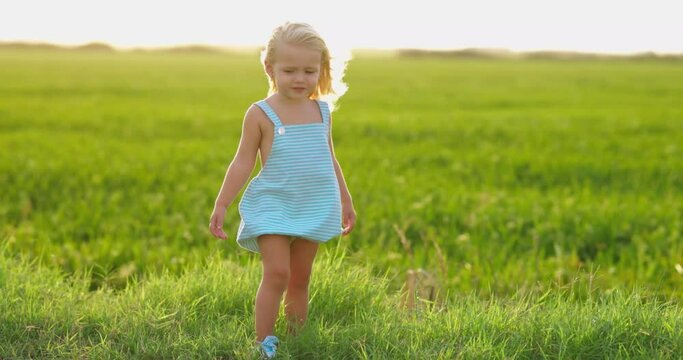 Ni&ntilde;a peque&ntilde;a en el campo al atardecer con brisa veraniega