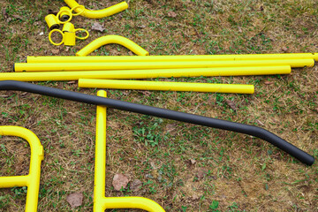 Photo of the yellow metal details of playground on the ground