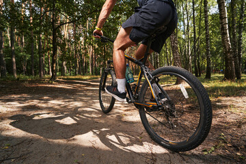 Fototapeta na wymiar Muscular young male riding bike in forest