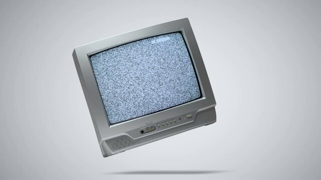 Old gray CRT TV hangs in the air and shows interference and static noise, switching channels, turning off, on a light gray background. Empty broadcast concept  