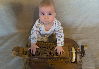 Little child with hurdy-gurdy: a nine-month-old child sits with his hands on the lid of a medieval...