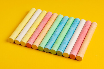 Colorful chalks on yellow background