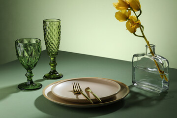 Beautiful table setting with flowers, green glass wine, plate for a dinner, wedding reception or...