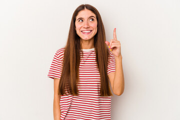 Young caucasian woman isolated on white background indicates with both fore fingers up showing a...