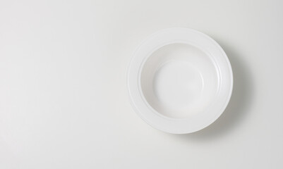 empty white round ceramic soup plate on white table, top view