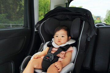 運転中の車のチャイルドシートに乗っている赤ちゃん