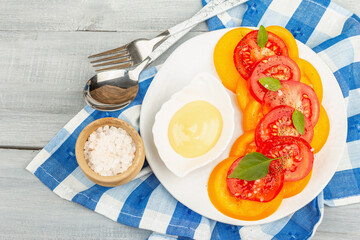 Vegan tomato salad with fresh basil leaves, spices, and delicious sauce