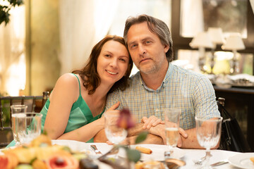 a man and a woman sit at a festive table. a middle-aged couple. 