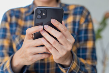 using cell phone hand holding mobile texting message contact us.chatting,search internet information in office.technology device communication connecting.