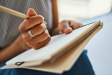 Female dressed in casual clothes making notes on a blank page