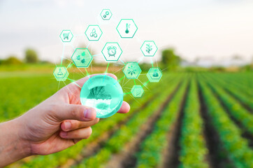 Holding a globe with innovations on farm field background. Use of innovative technologies in...