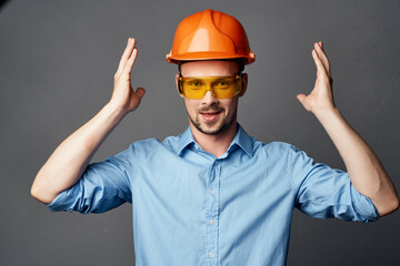 man in orange hard hat yellow glasses construction safety work