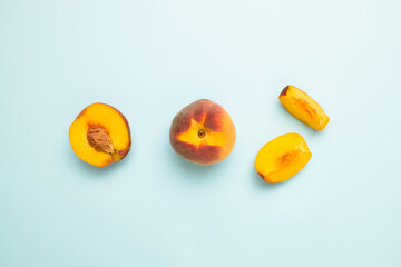 Flat composition with ripe peaches on colored blue background. Top view fresh organic fruit food with copy space