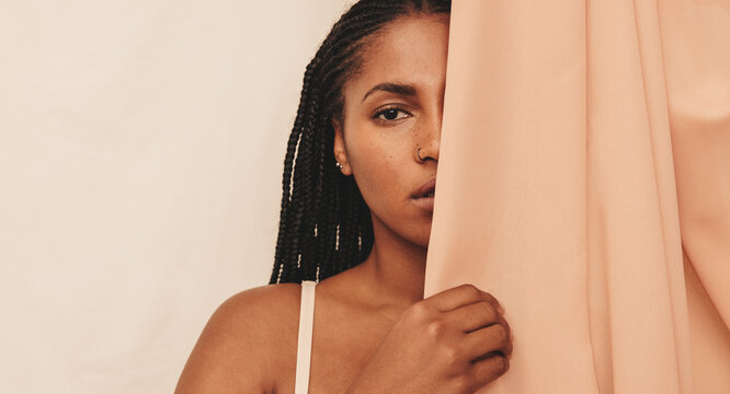 Young Woman Standing Behind A Studio Curtain