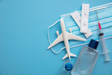 Covid air travel background. Airplane with a coronavirus protective face mask vaccine needle and...