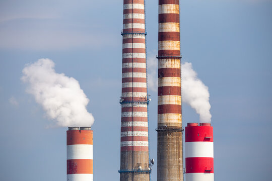A close-up of the smoking stacks of a coal-fired power plant. Photo taken on a sunny day with good lighting conditions.