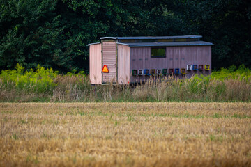 Fototapeta na wymiar A beekeeping trailer set up in a meadow near the forest. Photo taken in good lighting conditions on a sunny day.
