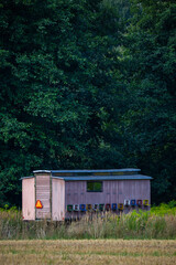 A beekeeping trailer set up in a meadow near the forest. Photo taken in good lighting conditions on a sunny day.