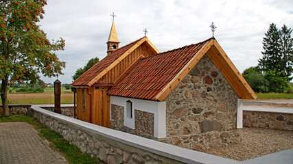 General view and architectural details of a brick Catholic chapel from 1863 and a wooden part added to it in 1905 in Pogorzalki in Podlasie, Poland.