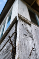 Rusty nails driven into the corner of an old wooden house in the countryside. Bottom view. 
