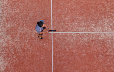 View from above of a paddle tennis player waiting for the ball in a match.