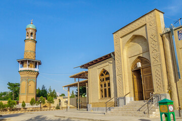 Fototapeta premium Entrance to Khoja Abdi Darun memorial complex, Samarkand, Uzbekistan. Mausoleum itself was founded in XII. Photo shows minaret of mosque and khanqah. Inscription on right translates as 'Donation box'