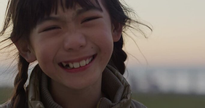 Portrait of asian japanese girl child smiling outdoors at sunset