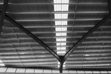 Interior architecture space and light atmosphere show long span steel structure roof with strip of skylight in black and white.