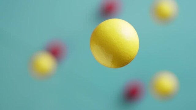 Yellow and red balls are moving on a blue background, 3D effect. Bright abstract background with spherical shapes.