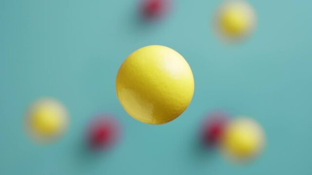 Yellow and red balls are moving on a blue background, 3D effect. Bright abstract background with spherical shapes.